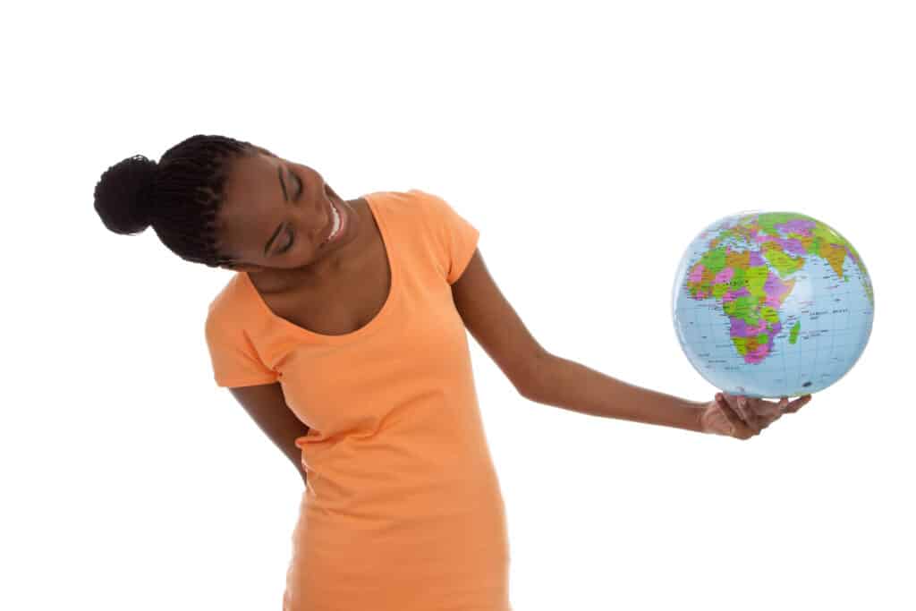 A Black female student holds a globe and considers where she will study.