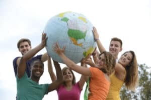 Diverse group of people holding a globe together